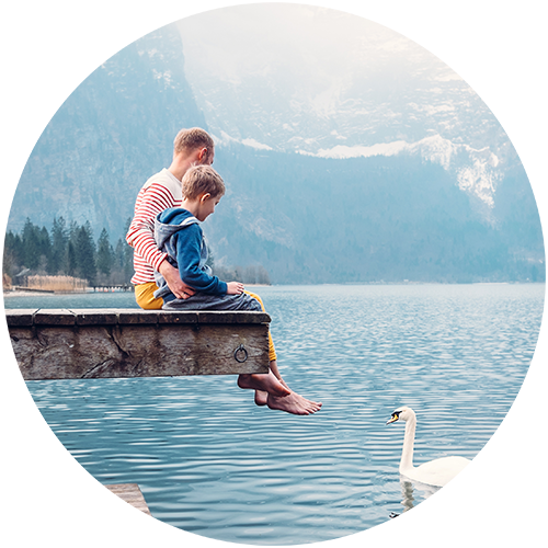 father and son talking by a lake