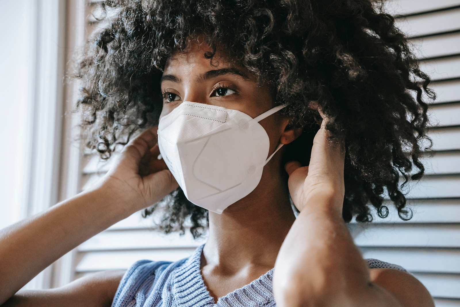 woman putting on a mask